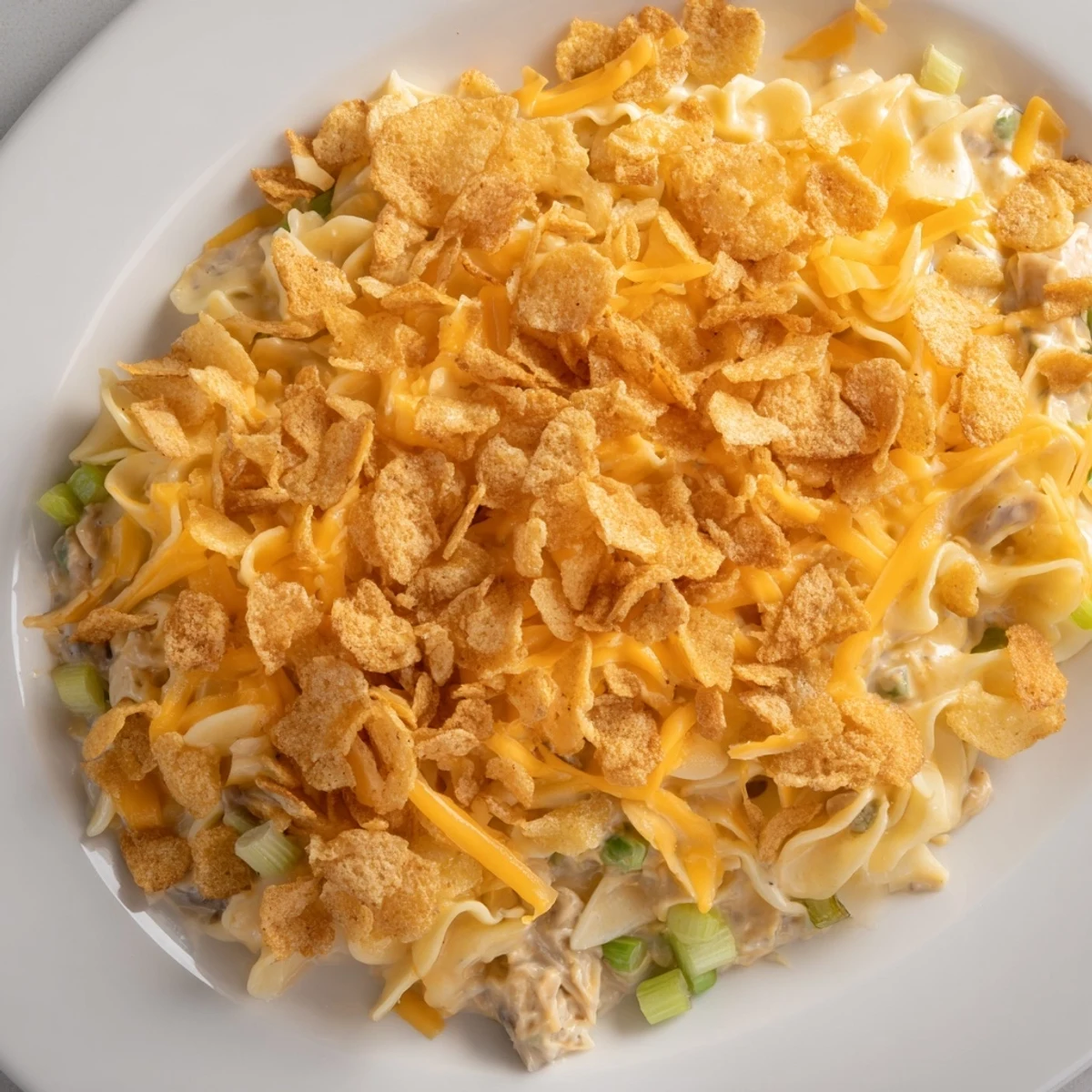 Golden, bubbly Budget Tuna Noodle Casserole with a crispy chip crust, ready for serving.
