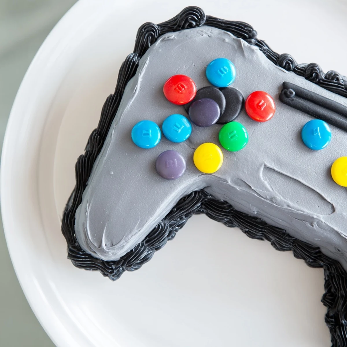 A close-up shot of the creatively decorated Pixel Perfect Video Game Controller Board cake.