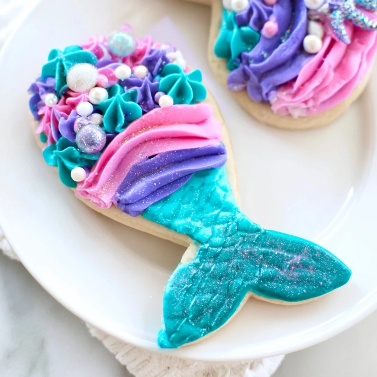 Imagine the ocean! Colorful mermaid tail sweets, frosted with swirled buttercream and edible glitter.