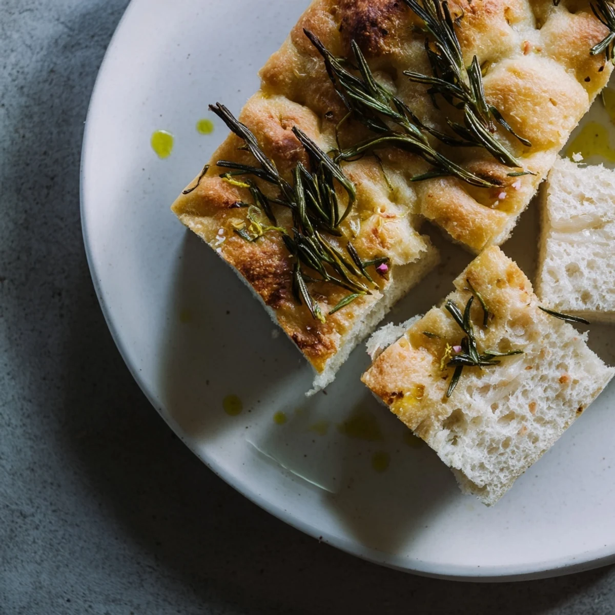 Golden, sliced Holiday Bread focaccia with fresh rosemary, ready to be served.