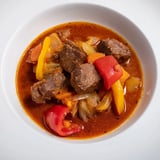 Imagine a bowl of Effortless Golden Beef Goulash, the richness inviting with side slices of warm, crusty bread.