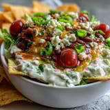 Festive Easy Taco Dip Cups with layers of refried beans, sour cream, and cheese in clear cups, topped with lettuce and tomatoes.