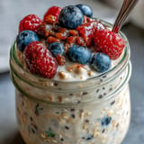 Enjoy high fiber overnight oats with bursting berries and crunchy nut toppings.