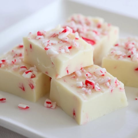 Smooth, creamy 5-Minute No-Bake White Chocolate Peppermint Fudge, studded with festive red and white candy pieces.