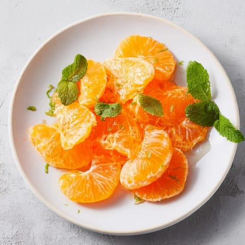 Close up shot of clementine and mint winter fruit salad, a beautiful vegetarian dessert.