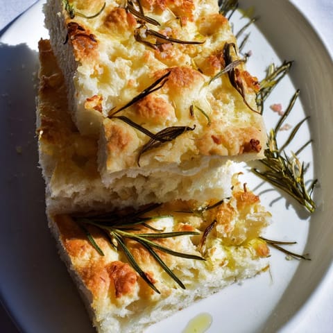 Warm Holiday Bread focaccia, crispy on the outside, soft inside, herbs glistening with olive oil.