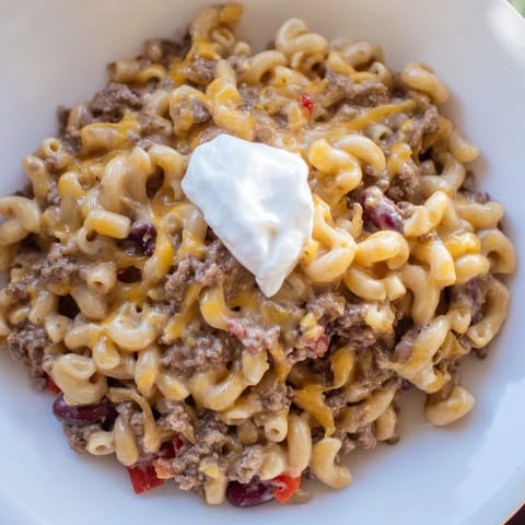 Steaming bowl of one-pot chili mac—ground beef, melted cheese, and creamy macaroni—perfect dinner.