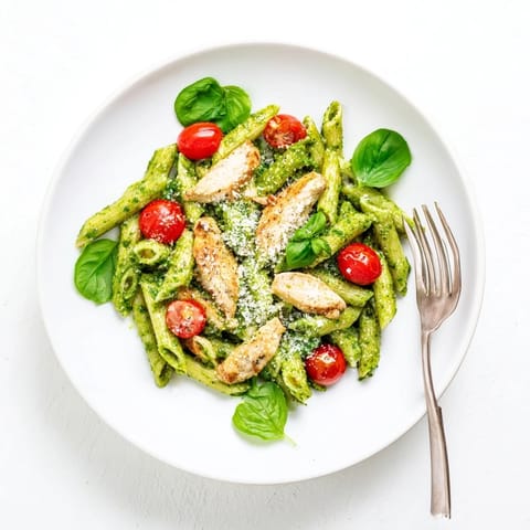 Golden grilled chicken slices and penne pasta coated in fresh basil pesto with cherry tomatoes and spinach.