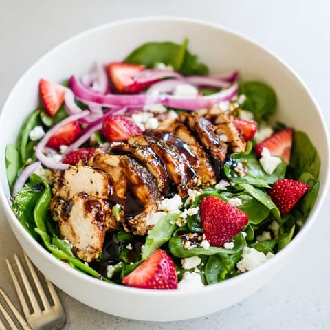 Strawberry Balsamic Chicken Salad features juicy berries and creamy feta tossed with crisp greens and toasted pecans for a refreshing summer meal.  