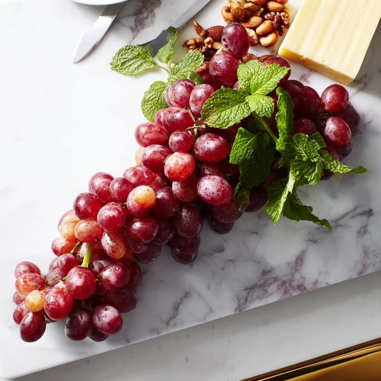 Vibrantly colorful grapes, some hanging over the edge, make an eye-catching appetizer presentation.