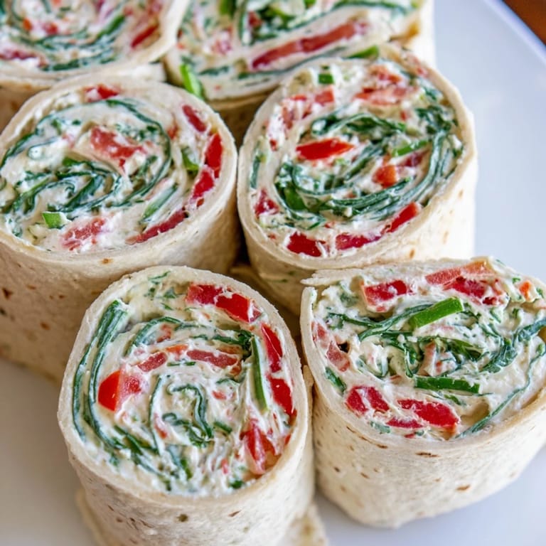 Close-up of freshly cut Christmas Scarf Tortilla Roll-Ups, ready to eat, bursting with flavorful ingredients.