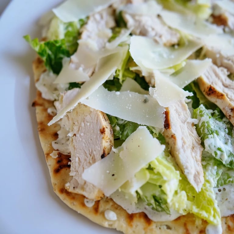 Warm flatbread layered with grilled chicken, Caesar salad, and optional cherry tomatoes.